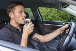 man blowing into breathalyzer